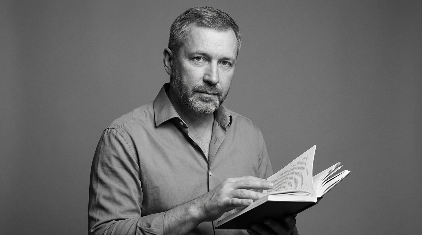 Дмитрий Соколов — портрет автора статьи в студийном освещении с книгой в руках